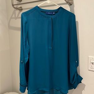 Woman’s teal blouse with black piping